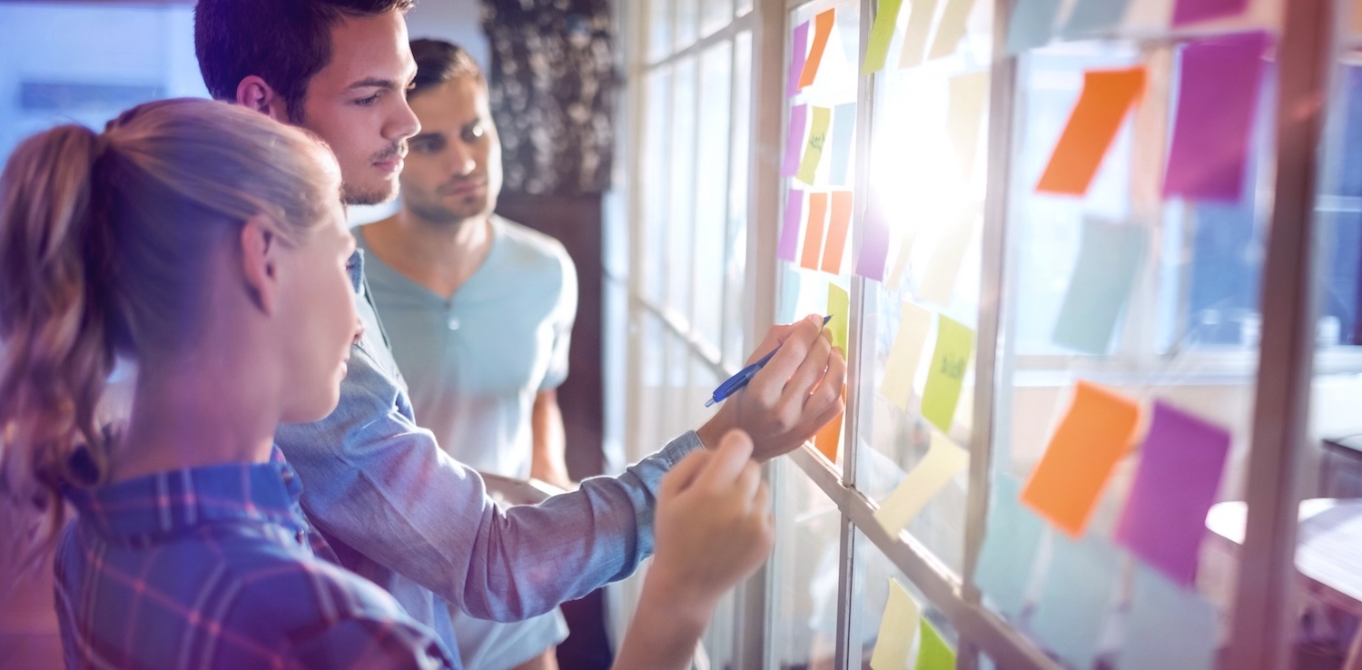 People writing on sticky notes